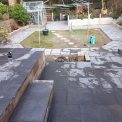 Customer had old slippery decking. We demolished it and built retaining wall and laid new patio slabs.